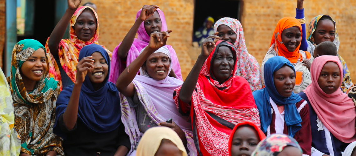 Group of women smiling with raised arms