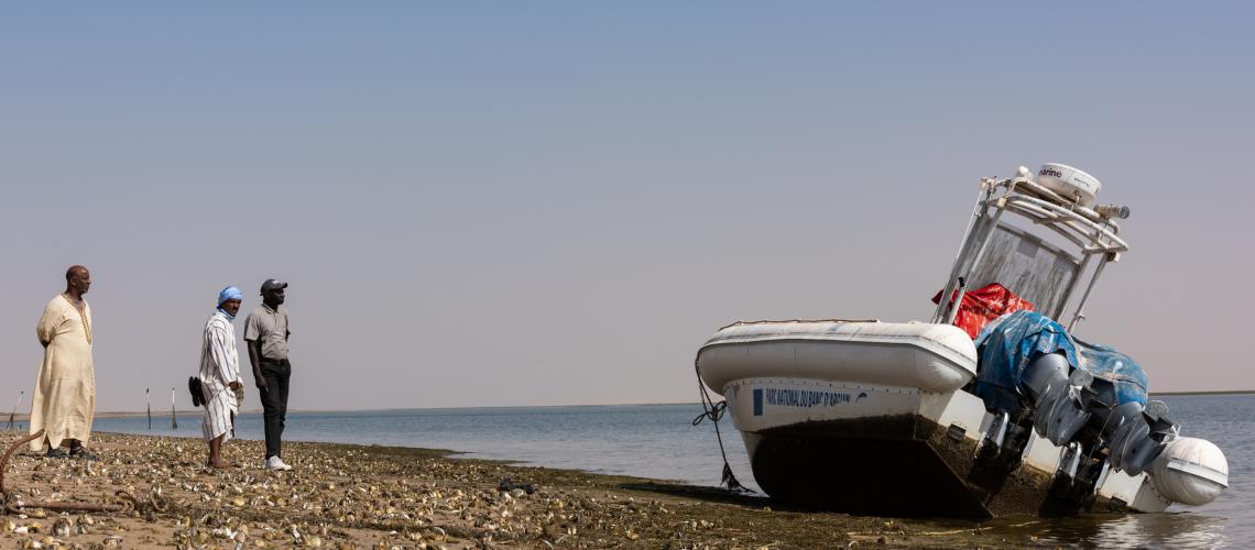 Men beside a boat on the beach