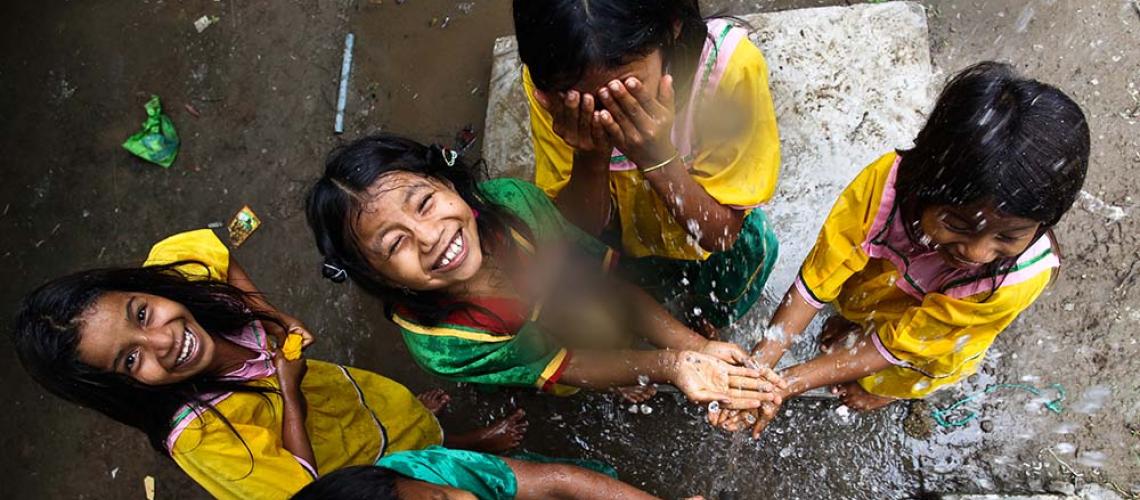 Young girls playing with falling water