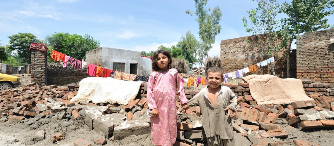 Children standing in front of a settlement