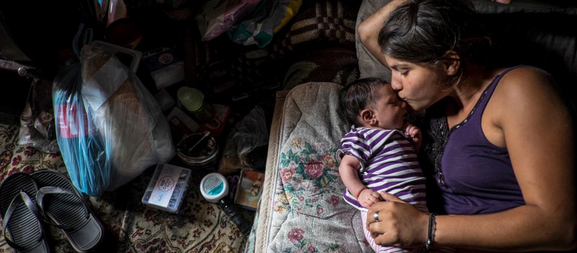 Woman laying on a mattress with a baby