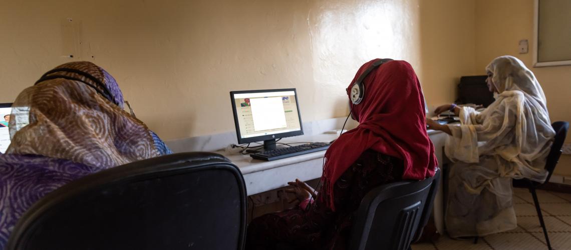 A group of women sitting in front of computers