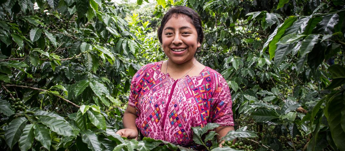 Woman surrounded by trees smiling at the camera