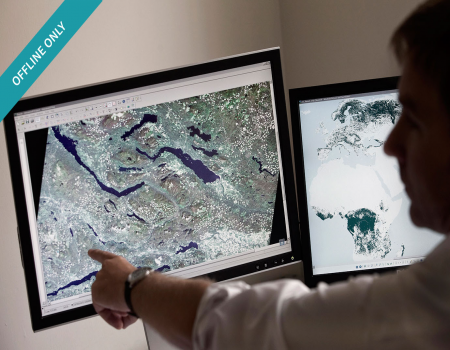 Man pointing to aerial mapping on a screen