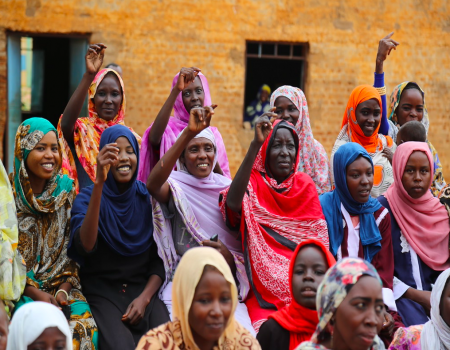 Group of women smiling with raised arms