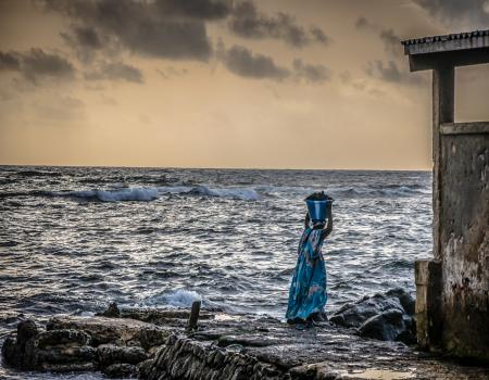 Woman carry resource in front of the sea